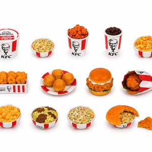 Peut inclure: Une collection de miniatures de plats KFC, comprenant un seau de poulet frit, de la salade de chou, du poulet popcorn, une boisson, du mac and cheese, des nuggets de poulet, des biscuits, un burger et un morceau de poulet frit dans un sac en papier.