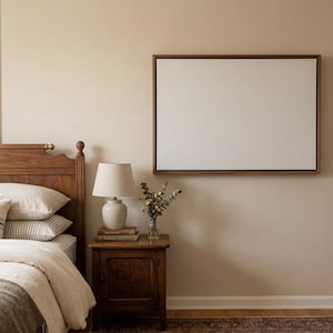 Puede incluir: Una escena de dormitorio con una cama de madera, una mesita de noche con una lámpara y un lienzo enmarcado en la pared. La cama está hecha con ropa de cama y almohadas blancas. La habitación tiene una paleta de colores neutros, creando un ambiente acogedor.