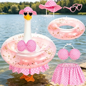 May include: A collection of pink and white polka dot summer accessories, including a swan-shaped inflatable pool float, a sun hat, heart-shaped sunglasses, a swim ring, and a bikini top and skirt. The float has a swan head with heart-shaped sunglasses.