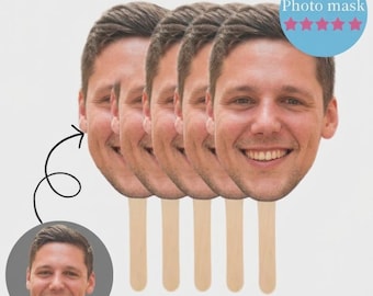 May include: A set of five photo masks featuring a smiling man's face, each attached to a wooden stick. A circular image of the same man is in the lower left corner. The text "Photo mask" is in a blue circle with pink stars.
