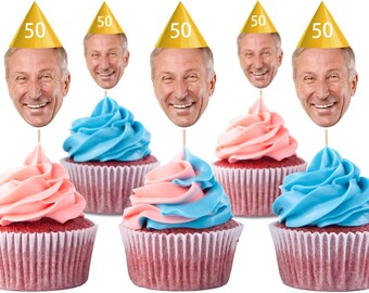 May include: Six cupcakes with red velvet cake bases and pink, blue, and two-tone frosting. Each cupcake has a face cutout on a stick, wearing a gold party hat with the number 50.