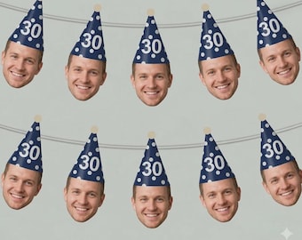 May include: A festive banner featuring multiple cutouts of a smiling person's face, each wearing a navy blue party hat with white polka dots and the number "30". The banner is strung on a thin, light-colored string, perfect for a birthday celebration.