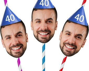 May include: Three straws with a smiling face attached, each wearing a blue party hat with the number 40 in white. The straws are striped in pink and white, blue and white, and red and white.