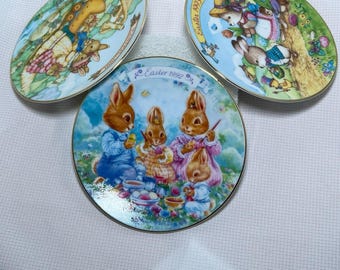 Conjunto de 3 pratos colecionáveis de Páscoa da Avon, 1991, 1992 e 1993, em porcelana com detalhes em ouro 22 quilates.