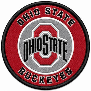 Puede incluir: Un parche bordado circular con el logotipo de la Ohio State University. El diseño incluye un fondo rojo con un centro gris, un borde negro y el texto OHIO STATE BUCKEYES en letras blancas y negras que rodean el emblema central.