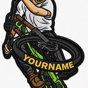 May include: Embroidered patch featuring a mountain biker in a helmet with red goggles, riding a black and green bicycle. The text "YOURNAME" is displayed on a banner across the bike. The patch has a black border.