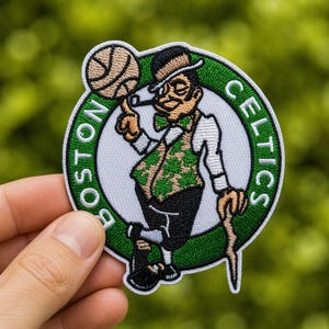 May include: Embroidered patch featuring the Boston Celtics logo. The patch shows a cartoon man in a green waistcoat, holding a basketball and a cane. The words "BOSTON CELTICS" are in green around the white background.