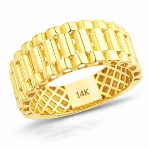 May include: A gold-colored ring with a textured, watch-band style design. The ring is made of 14K gold and features a repeating pattern of vertical bars. The inside of the ring has a diamond-shaped pattern and the text "14K".