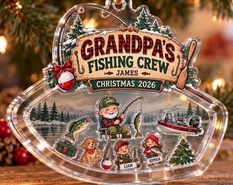 Pode incluir: Um enfeite de Natal em acrílico transparente em forma de boia de pesca, com o texto "GRANDPA'S FISHING CREW", "JAMES" e "CHRISTMAS 2026". O design inclui ilustrações de uma pessoa a pescar, um barco, um cão e árvores.