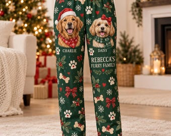 Pode incluir: Calças de pijama verde-escuras com uma estampa festiva de Natal com ilustrações de golden retrievers, laços vermelhos, ossos brancos, pegadas e flocos de neve. O texto diz Charlie, Daisy e Rebecca's Furry Family em letras brancas.