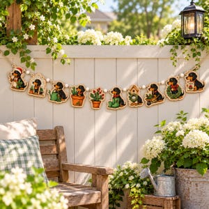 Pode incluir: Uma guirlanda de madeira com uma série de cães dachshund ilustrados em vários cenários de jardim, incluindo plantas em vasos, uma estufa, uma casa de pássaros e um carrinho de mão, unidos por pequenas contas de madeira branca.