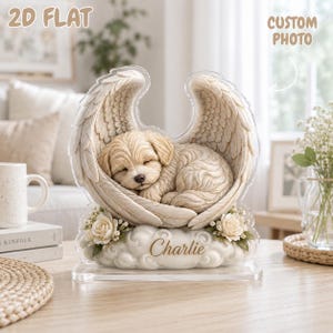 May include: A 2D flat acrylic display featuring a sleeping light-colored puppy nestled within large, detailed angel wings. The base is shaped like a cloud with the name Charlie printed in script, accented by small white roses on each side.
