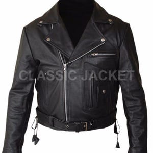 Könnte beinhalten: Eine schwarze Lederjacke mit breitem Reverskragen und silberfarbenen Druckknöpfen, asymmetrischem Frontreißverschluss, Taillengürtel mit Schnalle und mehreren Reißverschlusstaschen. Der Text CLASSIC JACKET ist auf der Brust aufgedruckt.