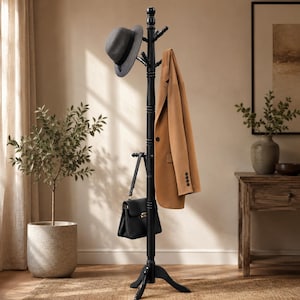 May include: A black wooden coat rack with a central pole, multiple hooks, and a tripod base. A grey fedora hat, a tan blazer, and a black handbag are hanging from the hooks. The coat rack features a turned wood design with a smooth finish.
