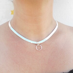 May include: A silver chain necklace with a small circle pendant.