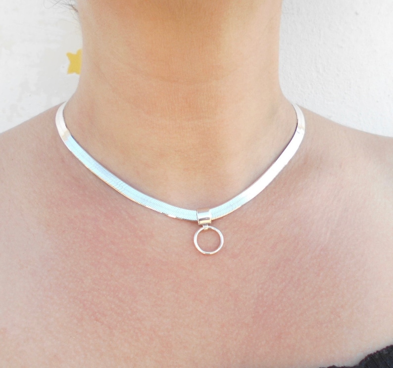 May include: A silver chain necklace with a small circle pendant.
