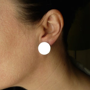 May include: A pair of white round stud earrings.