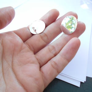 May include: Two silver oval-shaped metal blanks for jewelry making.