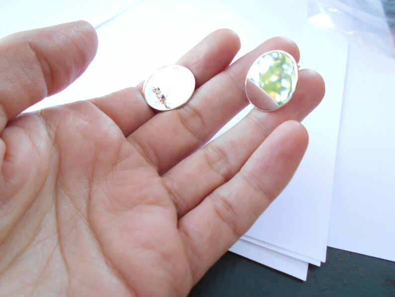 May include: Two silver oval-shaped metal blanks for jewelry making.