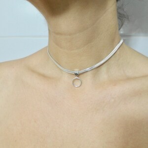 K&ouml;nnte beinhalten: Eine silberne Choker-Kette mit einem kleinen runden Anh&auml;nger.