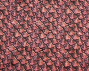 May include: A close-up of a fabric with a repeating pattern of overlapping scales. The scales are a deep red colour with a subtle shimmer, and the background is a dark brown.