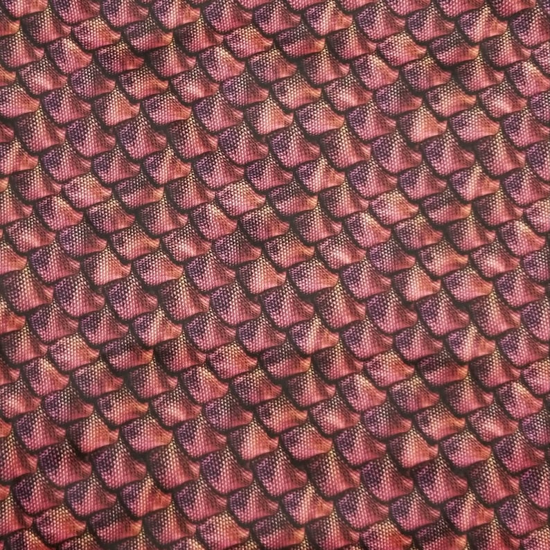 May include: A close-up of a fabric with a repeating pattern of overlapping scales. The scales are a deep red colour with a subtle shimmer, and they are arranged in a diagonal pattern. The fabric has a slightly textured surface.