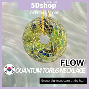May include: A Quantum Torus necklace with a gold chain. The pendant is a sphere with a central opening, constructed from gold wire and green, blue, and yellow glass pieces. The word "FLOW" is displayed in large, bold letters.