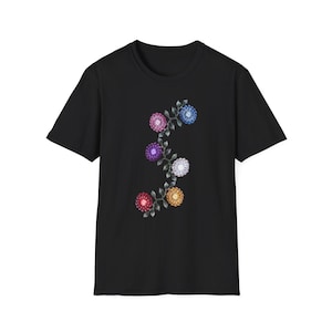 May include: A black short-sleeve t-shirt featuring a central vertical graphic of a winding vine with dark green leaves and six multi-colored spherical flower blossoms in shades of pink, blue, purple, white, red, and orange.