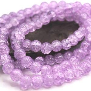 May include: Strands of light purple, round beads. The beads have a cracked, textured appearance. The beads are strung together, creating a necklace or bracelet component. The beads are approximately 8mm in diameter.