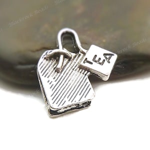 May include: Silver charm shaped like a tea bag with a tag that says "TEA".