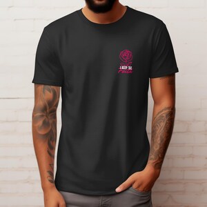 Peut inclure: T-shirt noir avec une rose rose et le texte "I keep the faith". Le motif est situ&eacute; en haut &agrave; gauche de la poitrine. Le t-shirt est fait d'une mati&egrave;re douce.