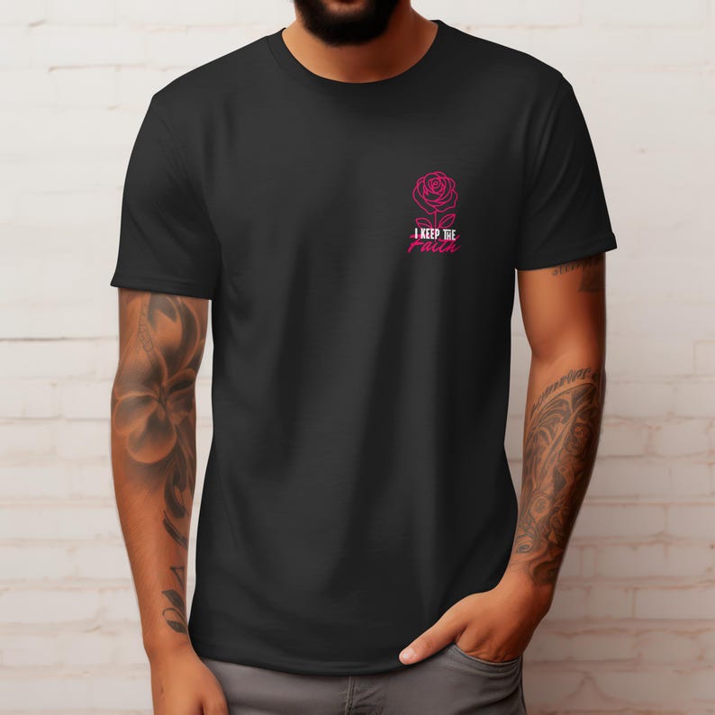 Peut inclure: T-shirt noir avec une rose rose et le texte "I keep the faith". Le motif est situ&eacute; en haut &agrave; gauche de la poitrine. Le t-shirt est fait d'une mati&egrave;re douce.