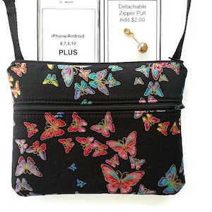 May include: Black crossbody bag with a butterfly print. The bag has two zippered compartments and a detachable zipper pull. The bag is large enough to fit an iPhone or Android phone up to 6, 7, 8, or 10 Plus.