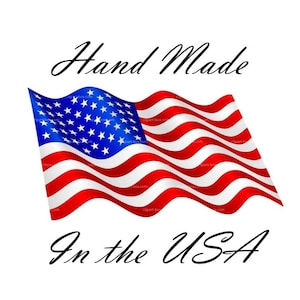May include: A graphic illustration of a waving American flag featuring red and white horizontal stripes and a blue canton with white stars. The text Hand Made is positioned above the flag, and the text In the USA is positioned below the flag.