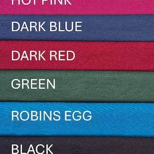 May include: A color chart featuring eight horizontal fabric swatches labeled with white text: Purple, Hot Pink, Dark Blue, Dark Red, Green, Robins Egg, Black, and Gold. Each swatch displays a distinct solid color with a visible fabric texture.