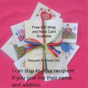 May include: A white rectangular package wrapped with thin red, green, and blue ribbons, surrounded by various greeting cards featuring illustrations of a Christmas tree, a graduation cap, and flowers, with text stating Free Gift Wrap and Note Card Available.