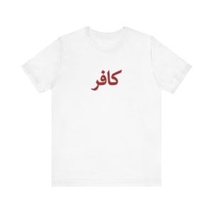 May include: White t-shirt with the Arabic word "Kafir" printed in red. The shirt is a basic crew neck style, suitable for casual wear.