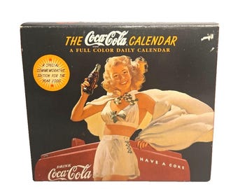 Calendario de escritorio diario de Coca-Cola 2000, edición conmemorativa, con anuncios vintage en caja.