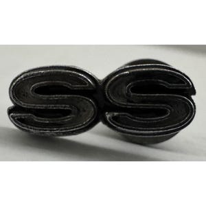 May include: A vintage, silver-toned metal emblem featuring the letters "SS" in a stylized, overlapping design. The emblem has a slightly weathered appearance, suggesting age or use. The letters are thick and rounded, with a classic font.