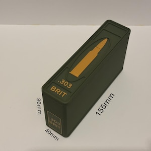 May include: An olive green rectangular box with a gold bullet graphic and the text ".303 BRIT". The box measures 15.5cm long, 8.6cm high, and 4cm wide.