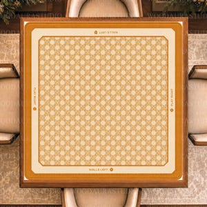 May include: A square mahjong table mat featuring a central cream-colored field with a repeating geometric pattern in light orange. The border is a solid orange band with the text WALLS LEFT and PLAY RIGHT printed in small black letters on each side.