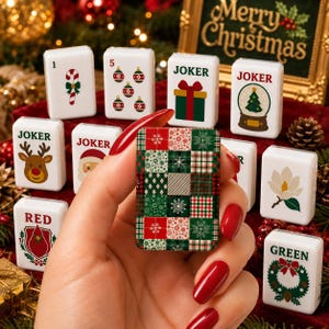 May include: A set of white rectangular mahjong tiles featuring various Christmas-themed illustrations including a candy cane, ornaments, a gift, a snow globe, a reindeer, Santa Claus, a cardinal, a magnolia, and a wreath, with one tile showing a plaid pattern.