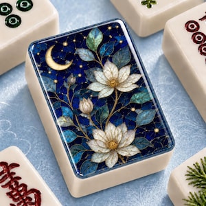 May include: A rectangular mahjong tile featuring a detailed illustration of two white lotus flowers and teal leaves against a dark blue starry night sky with a crescent moon. The tile has a smooth, off-white border and a glossy, flat surface finish.