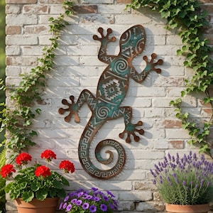 May include: A large metal gecko wall art piece with a turquoise and brown finish, mounted on a white brick wall. The gecko features intricate tribal patterns. Red geraniums and purple lavender plants are in terracotta pots below.
