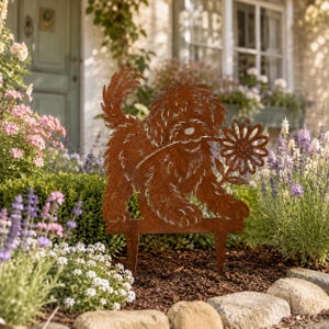 May include: A rust-colored metal garden stake featuring a silhouette of a shaggy dog holding a single daisy flower in its mouth. The cutout design shows the dog standing on two pointed metal prongs intended for insertion into the ground.