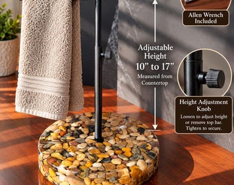 May include: A black metal towel stand with a round base filled with smooth, multi-colored river stones. The stand features an adjustable height from 10 to 17 inches, a 9-inch diameter base, a height adjustment knob, and an included Allen wrench.