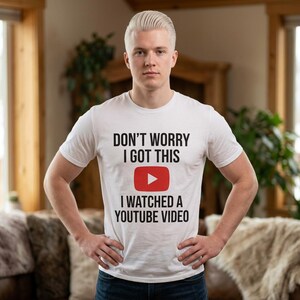 May include: White t-shirt with the text "DON'T WORRY I GOT THIS" above a red YouTube play button and the text "I WATCHED A YOUTUBE VIDEO". The shirt is short-sleeved.