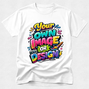 May include: A white short-sleeved t-shirt featuring a colourful graphic with the text "Your OWN IMAGE OR DESIGN" in a bold, graffiti-inspired font. The design includes a small camera icon, a paintbrush, and vibrant splashes of blue, pink, and yellow.