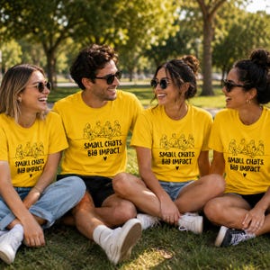 May include: A bright yellow t-shirt featuring a black line art illustration of four people sitting together and the text "SMALL CHATS. BIG IMPACT." with a small heart symbol printed on the front centre of the chest area.