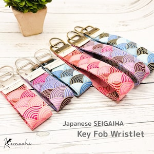 May include: Key fob wristlets with Japanese Seigaiha wave pattern in pink, red, purple, blue, and gold. Each wristlet has a metal key ring and a matching fabric loop. The Komachi Stitch Studio logo is visible on the wristlets.
